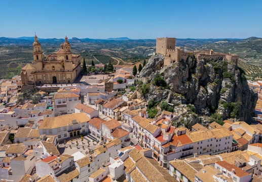 Aerial view of the historic Olvera Castle and the Church of Nuestra Senora de la Encarnacion overlooking white houses and olive groves in Olvera, Andalusia, Spain.