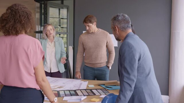 Architects and engineers discussing project on blueprint during a brief