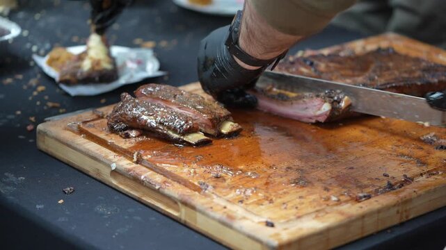 Close-up video of grilled ribs on a barbecue grill, showcasing the juicy and charred texture of the meat.
