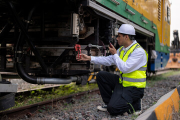 Fototapeta premium Railway Maintenance Engineer Inspecting and Repairing Train Track Components Outdoors
