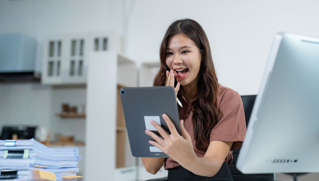 Overjoyed, Asian female businessman celebrates a financial bonus.