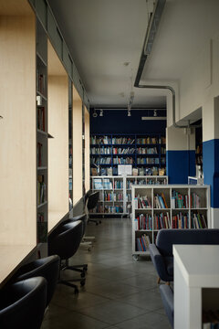 Vertical shot of modern library interior featuring study desks and bookshelves, supporting student learning and academic research
