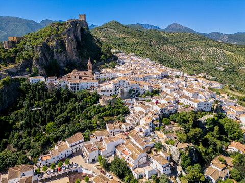 Aerial view of Zahara de la Sierra white village with its historic castle on a rocky cliff and the church of Santa Maria de la Mesa Zahara de la Sierra, Andalusia, Spain.