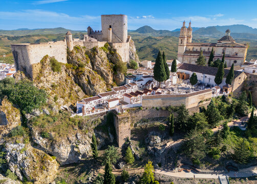 Aerial view of the medieval Castle of Olvera and the Church of Nuestra Senora de la Encarnacion on a rocky hill overlooking the white village and hills in Olvera, Andalusia, Spain.