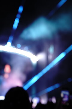 Abstract colorful concert bokeh background with blurred stage lights and glowing pink light stick silhouette, creating an energetic nightlife and live music atmosphere with soft defocused illumination