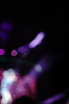 Abstract colorful concert bokeh background with blurred stage lights and glowing pink light stick silhouette, creating an energetic nightlife and live music atmosphere with soft defocused illumination