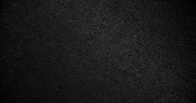 Dark Rough Texture Seamless Loop. Subtle continuous movement across a deep black rough textured surface with fine grain and soft light gradients. 