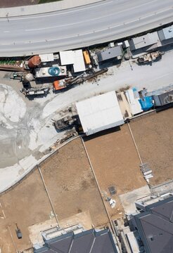 Aerial view of a construction site with heavy machinery, excavators, and temporary structures next to a road in Avcilar, Istanbul, Turkiye.