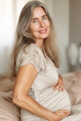 Naklejka premium Mature pregnant woman smiling portrait indoors natural light motherhood lifestyle concept