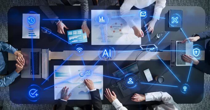 Top Down View of Business Team Collaborating Around Office Desk With Laptops and Charts as Linked Visualization Layer Appears, Glowing Ai Icons Symbolize Connectivity, Productivity and Cybersecurity.