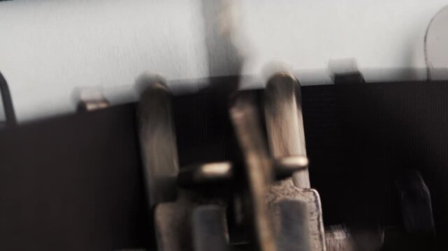 Typewriter produces text on paper that reads confidential during work hours at a desk in an office setting