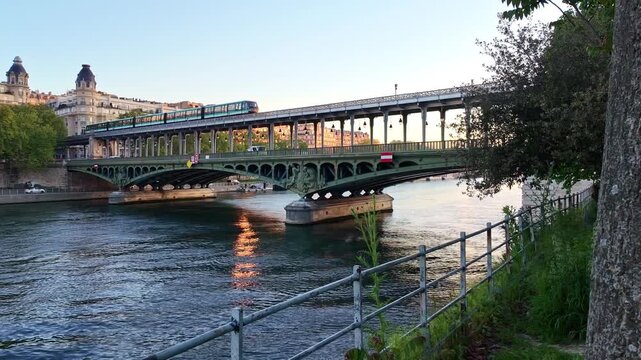 Modern skytrain travels over Bridge of Bir Hakeim or Pont de Bir-Hakeim bridge crossing the Seine River peaceful environment at sunrise, Paris, France