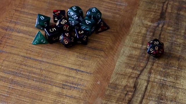 A pile of dice lay on a tavern table, a player rolls a D20 dice and rolls a natural 20.
