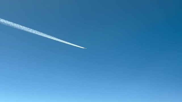 pilot&rsquo;s view of a jet airplane flying through a blue sky, as viewed from anothe jet cockpit