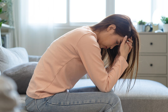 Depression in teenage concept, Young women covering her face feeling anxious and unhappy lock themselves at home sad emotional alone, and have mental disorders.