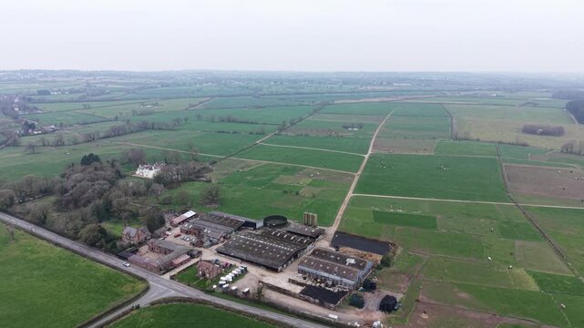 Aerial video showing farmland fields leading toward a countryside horizon line.