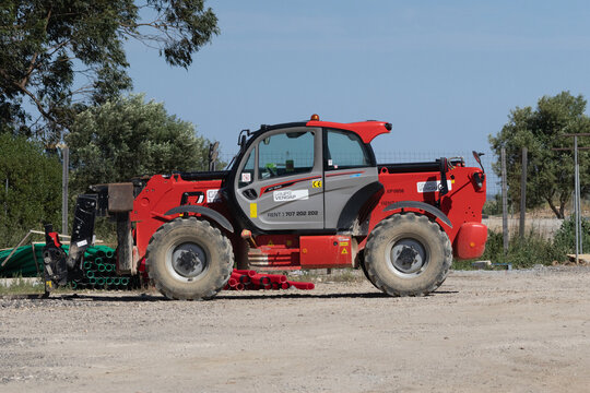 Red manitou telehandler parked on construction site