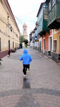 Boy Running Through Historic Calle Tarija in Potosi Bolivia