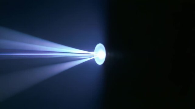 Light beam passing through a convex lens, creating a striking blue optical flare, illustrating principles of refraction and focusing in physics and optical science