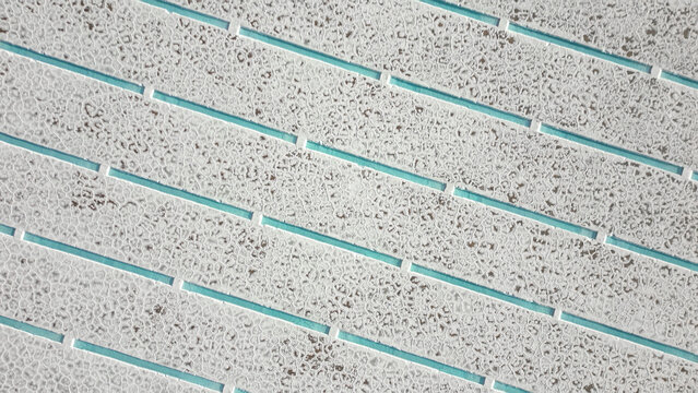 Aerial view of Salinas Grandes salt flats with turquoise water pools and geometric salt crust patterns in Tumbaya, Jujuy, Argentina.