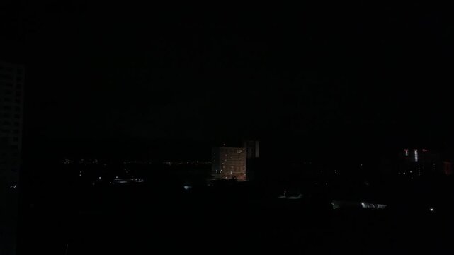 Dark city skyline during nighttime blackout, urban power outage and low light atmosphere concept with mysterious minimalist cityscape background.