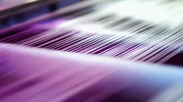 Purple yarn stretched across a weaving loom in a textile factory, close up of warp and weft creating patterned fabric, highlighting industrial precision and modern production
