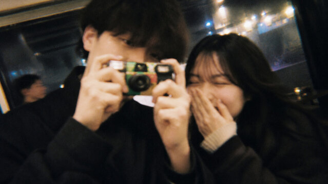 フィルムカメラ風のぼやけた質感で撮影した夜デート中の若い男女の記念写真