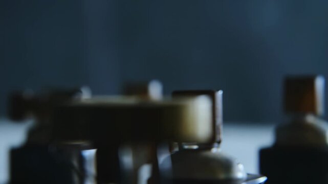 Industrial equipment detail showing an intricate part of a technological mechanism, moving or processing material with precision on a textured surface under dim lighting