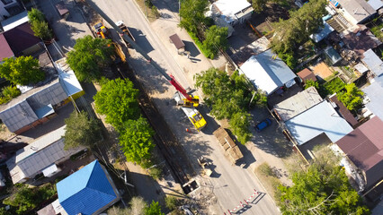 Fototapeta premium Aerial View of Mobile Truck Crane and Excavator on City Street Utility Repair Site