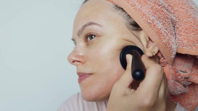 Woman performing a facial massage with a vacuum cupping device, promoting lymphatic drainage, skin health, and anti aging benefits as part of her daily skincare routine