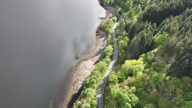 Top Down Drone Flight Over Road, Trees and Loch Leven Panning Up to Reveal the Glen, Horizon and Passing Car