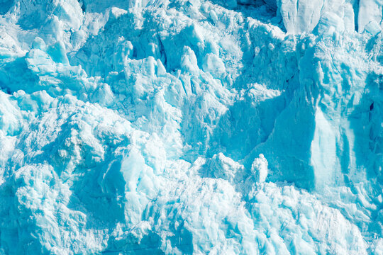 View of Lilliehookbreen glacier showing jagged ice formations and deep blue crevasses under bright daylight Svalbard, Svalbard and Jan Mayen.