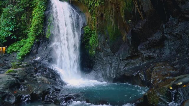 Scenic tropical waterfall cascading into beautiful natural rock pool in lush jungle 4K