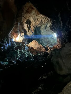 Gigantesca cueva con un rayo de sol que entra por la entrada e ilumina el interior
