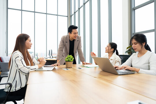 A group of professionals engage in a collaborative meeting in a modern office. The scene highlights teamwork, leadership, dynamic communication in a productive corporate environment.