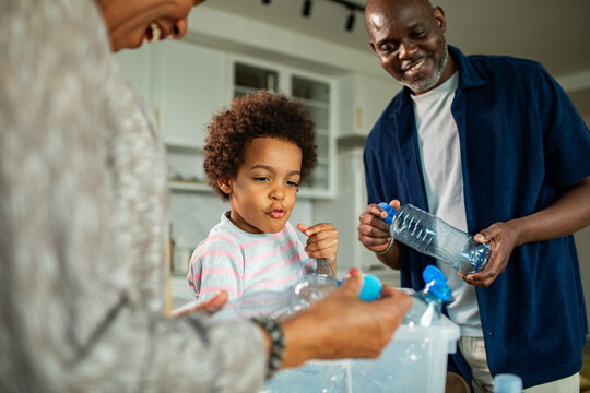 Family recycling plastic bottles in home kitchen