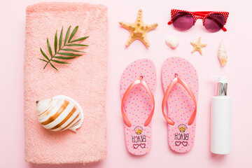 Naklejka premium Summer holiday concept. Top view of beach towel, flip flop and sunscreen cream on table Top view with copy space for text