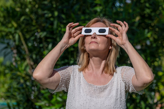 A woman has special glasses to observe the sun during an eclipse