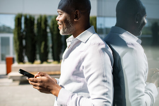 Mature man using smartphone outside office building