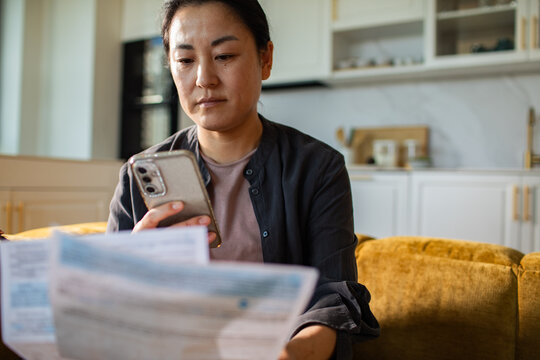 Woman reviewing bills and paying online at home