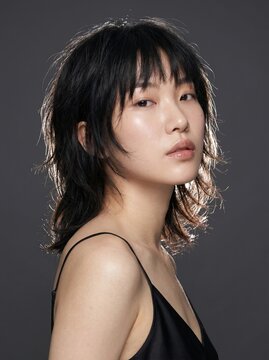 Young Asian woman with shaggy haircut in black slip studio portrait