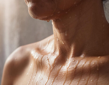 Close-up of a persons wet shoulder and neck in the shower.