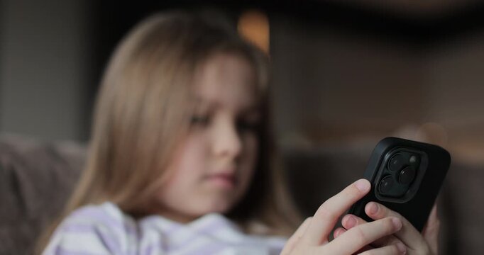 Child little girl daughter kid teen with phone resting on couch in living room. daughter sing mobile application modern technology online chat internet games at home.