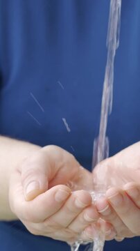 Save water. water flowing into the hands of an unrecognizable person.