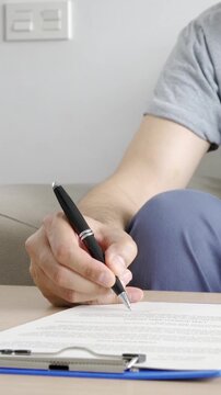 Close-up on a man signing a deed while buying a house - home ownership concepts