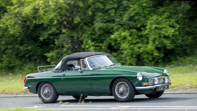Milton Keynes,Bucks,UK - May 21st 2026:  1971 green MGB  classic car driving on a British road