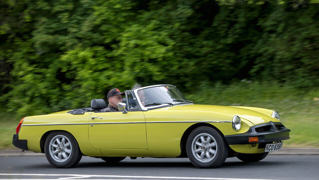 Milton Keynes,Bucks,UK - May 21st 2026: 1976 yellow MGB  classic car driving on a British road