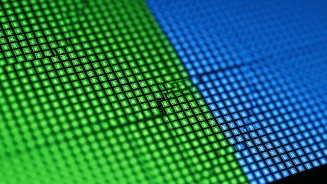 Close-up LCD pixel grid displaying red green blue color blocks, magnified matrix of glowing square elements on digital screen, abstract technology pattern and electronic display structure