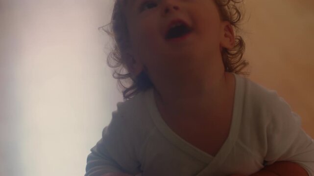 Toddler riding small scooter across bedroom floor during indoor playtime capturing balance learning, coordination and authentic early childhood mobility at home