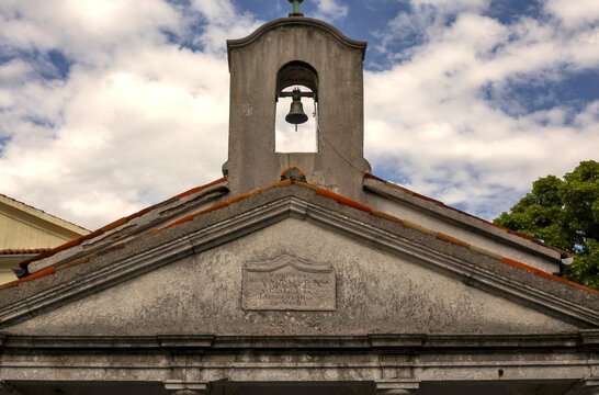 KASTAV, CROATIA. A low-angle shot of the stone belfry cot (distaff bell tower) featuring a single bronze bell at the Church of St. Sebastian and Fabian (Crkva sv. Sebastijana i Fabijana).